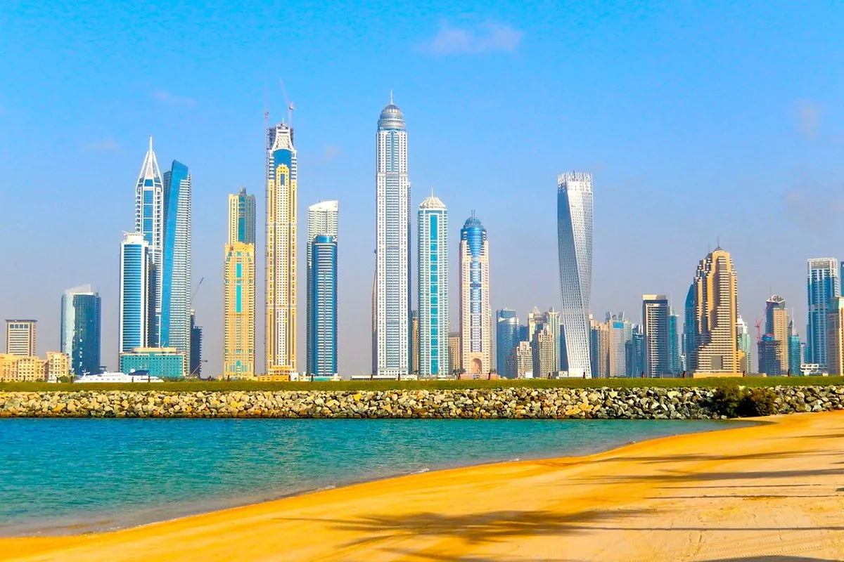The Dubai Marina skyline seen from a sandy beach